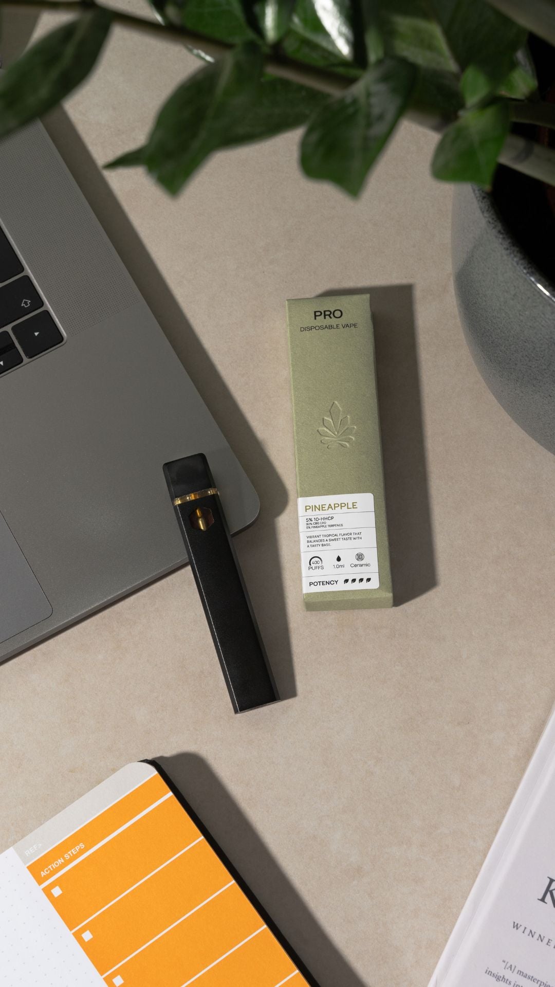 Nine Realms 10-OH-HHCP pro vape laying on a macbook in the office