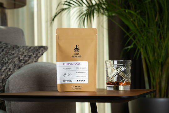 nine realms purple haze classic flower on the table with a glass of whiskey next to it