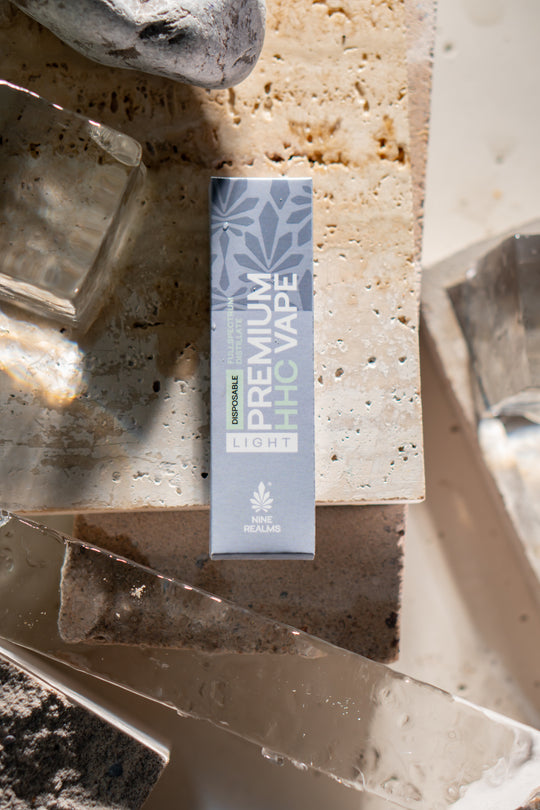 nine realms premium hhc vape packaging in a natural artistic composition