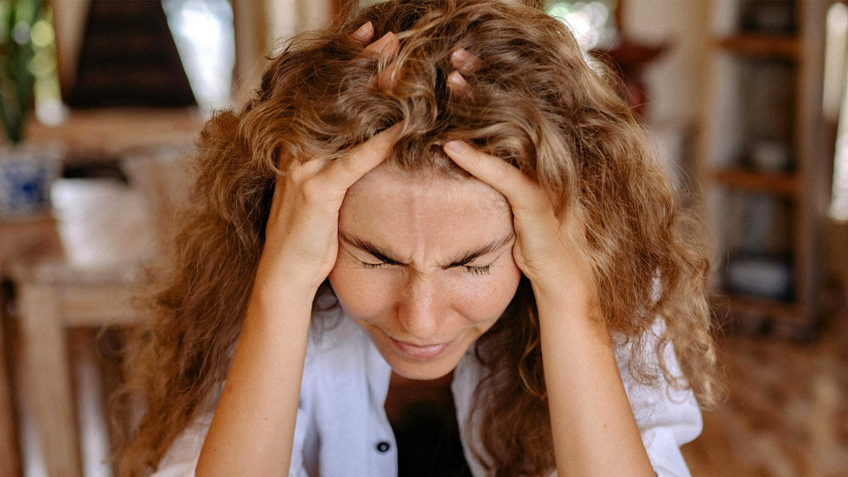 Nine Realms customer stressed holding her head in the living room