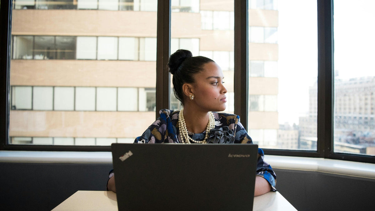 Nine Realms Customer sitting in the office with a laptop in front of her