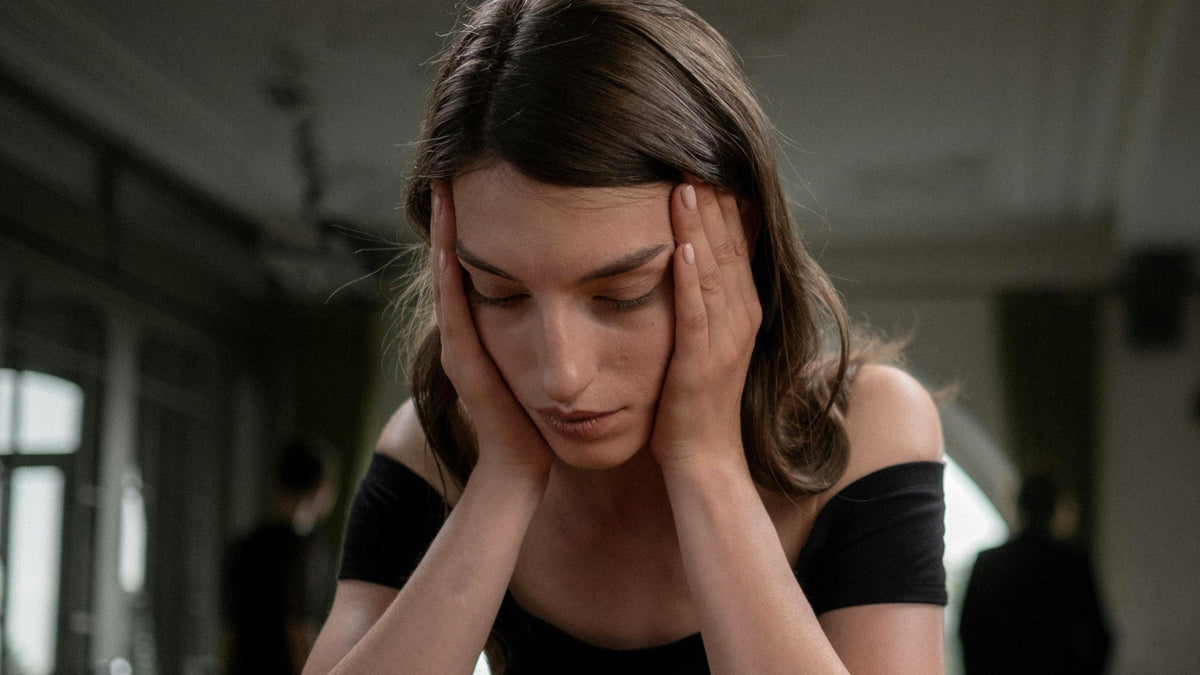 Nine realms customer in pain sitting in a black dress