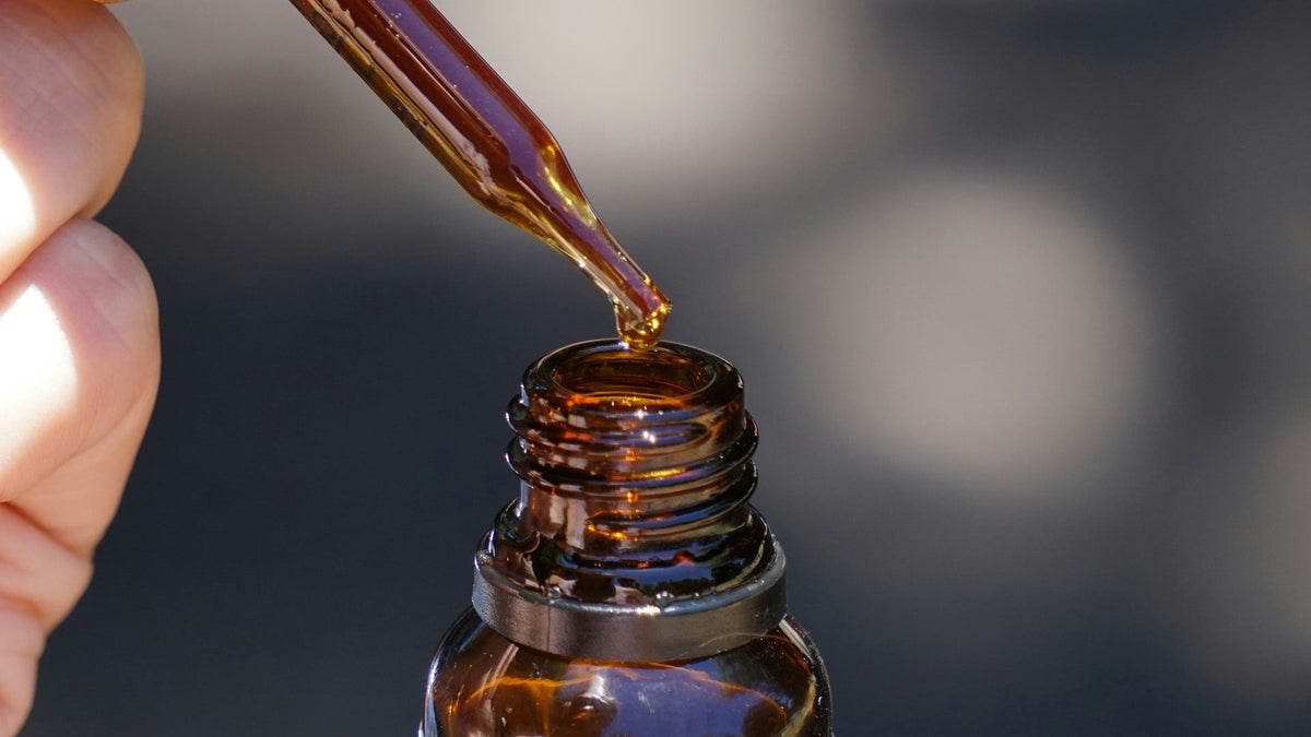 A hand dripping Nine Realms THCA tincture