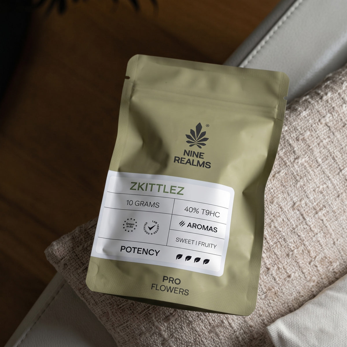 Nine Realms Zkittlez T9HC Blüten, 10g PRO-Beutel auf einem Sofakissen