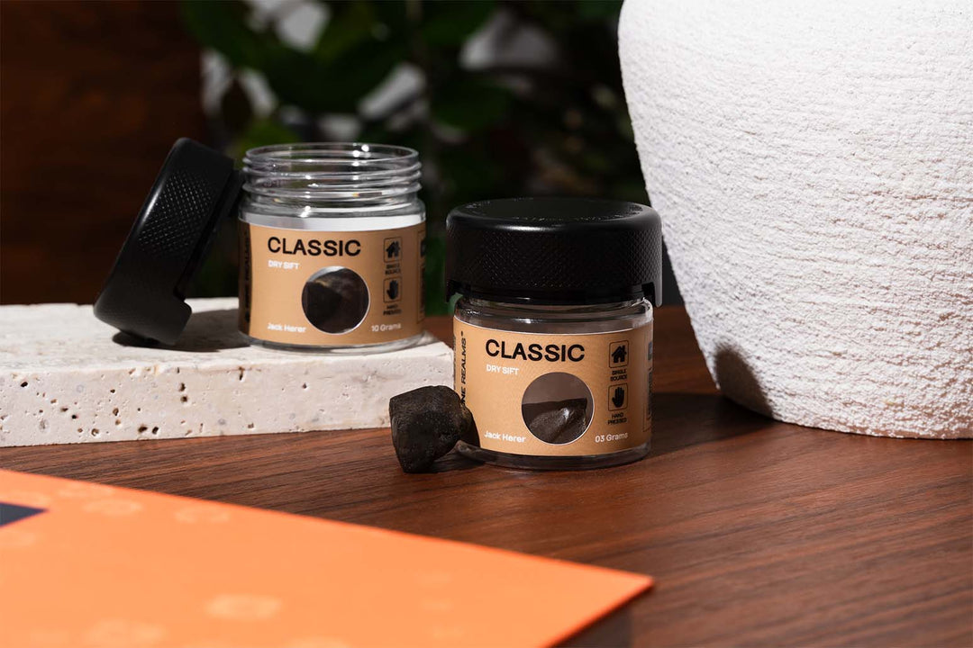 Nine Realms T9HC Dry Sift Hash on a wooden table with marble blocks next to it